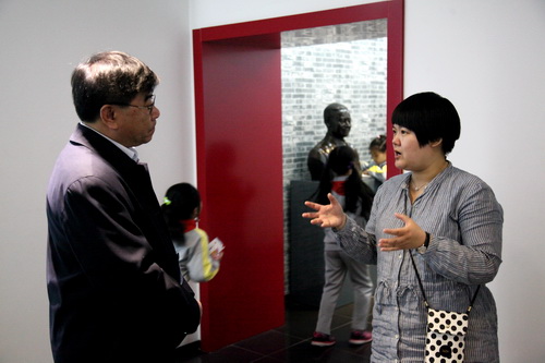 2学院办公室主任为新开路东总部小学领导介绍京剧展的情况_调整大小