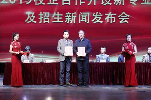 11北戏院长刘侗（右）和北京劲松职业高中校长郭延峰（左）交换《校企合作联合办学协议》文本