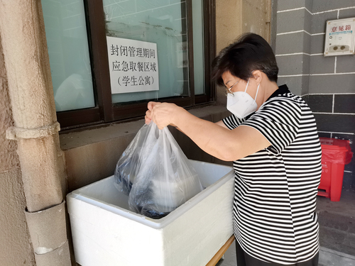 公寓老师为不能出宿舍的学生分发午饭