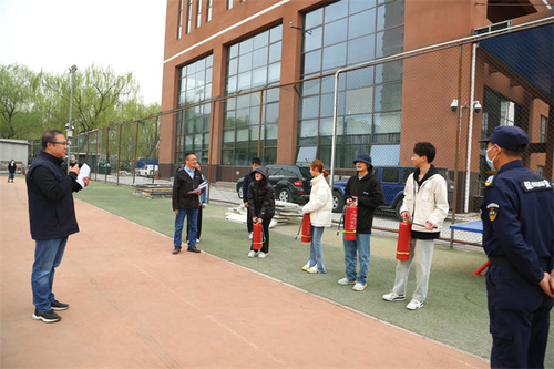 焦振宇副院长与消防支队警官一同指导学生使用灭火器